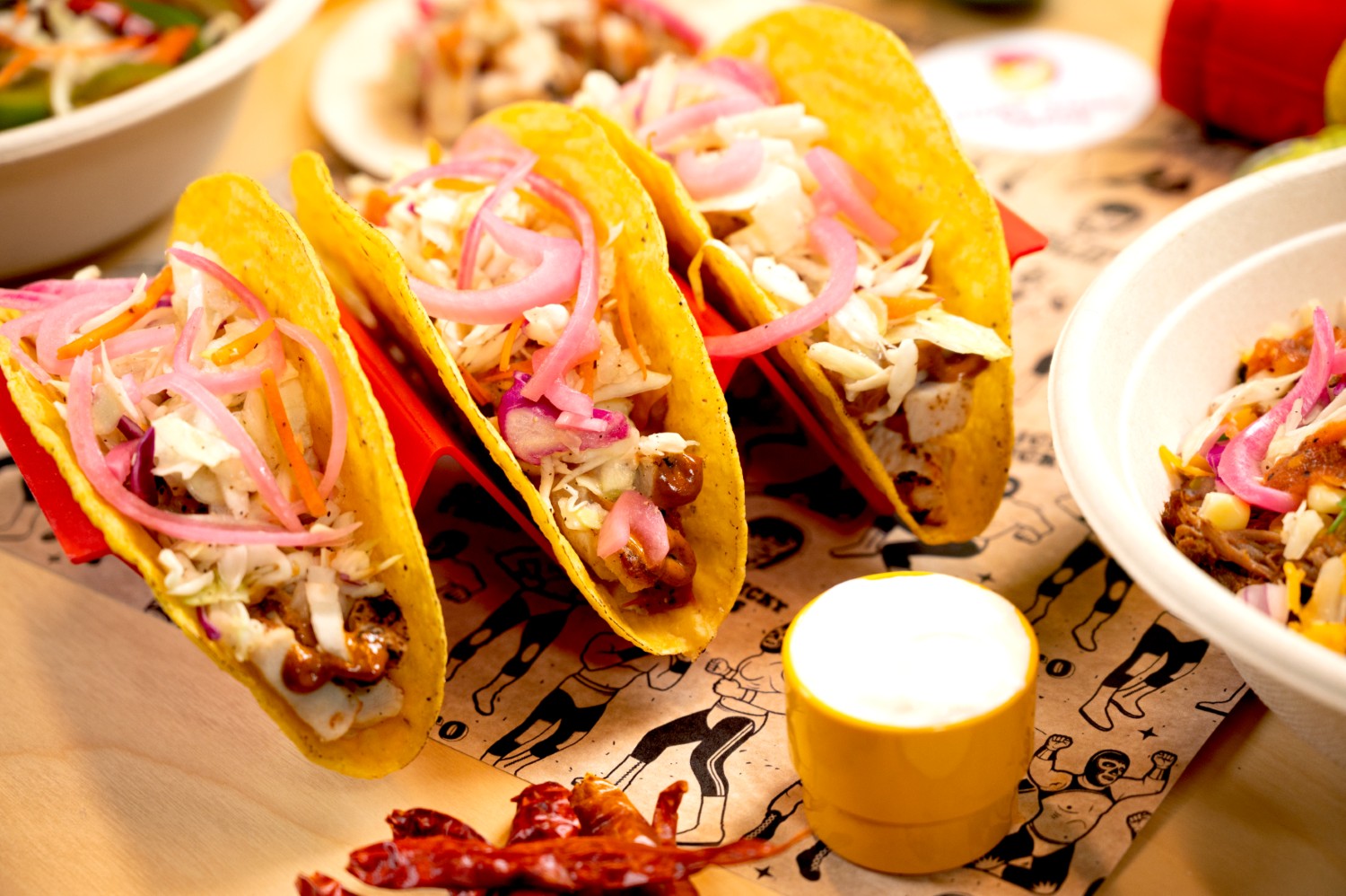 Tacos and sides styled on a bright taqueria table.