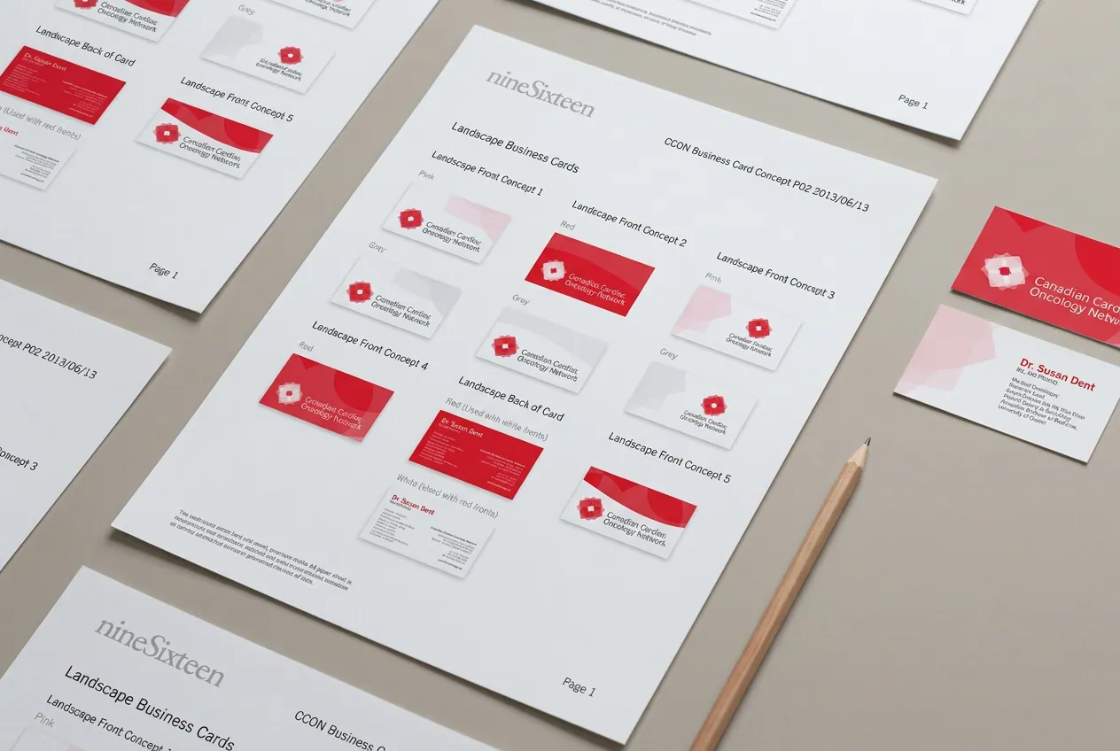 Printed CCON business card concept sheets laid out on a desk with sample cards.